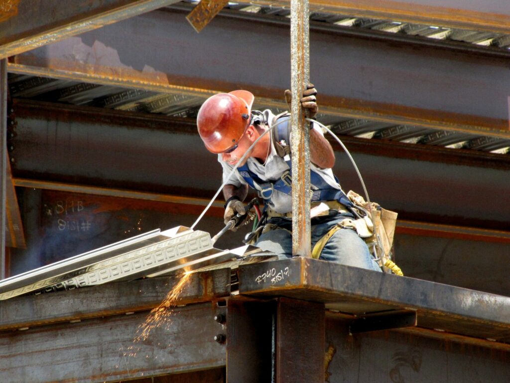 Un homme déconstruit une structure métallique sur un chantier de déconstruction.